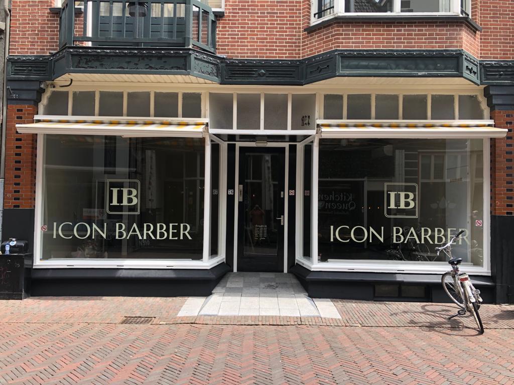 De gevel van Icon Barber aan de Nieuwstraat 76: deur in het midden en twee ramen met het IB-logo